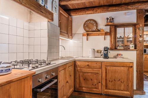 a kitchen with wooden cabinets and a stove at Da La Auri in Canale dʼAgordo