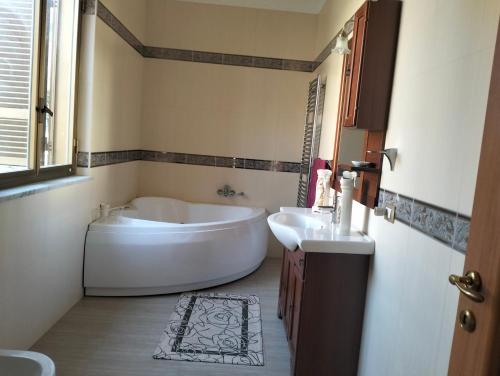 a bathroom with a large tub and two sinks at terrazza sul castello in Roccella Ionica
