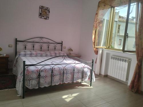 a bedroom with a bed and a window at terrazza sul castello in Roccella Ionica