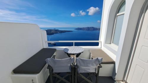 a balcony with a table and chairs on a cruise ship at Yposkafo Suites - Studio - Santorini in Fira
