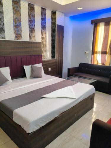 a bedroom with a large bed and a couch at Hotel SP international Lucknow in Lucknow
