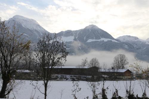 a house in front of a snow covered mountain at Hotel Köppeleck in Schönau am Königssee