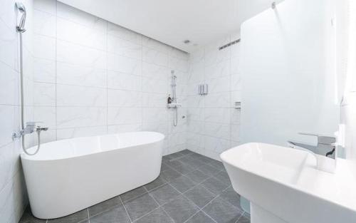 a white bathroom with a tub and a sink at Dangjin Dubai Hotel in Dangjin