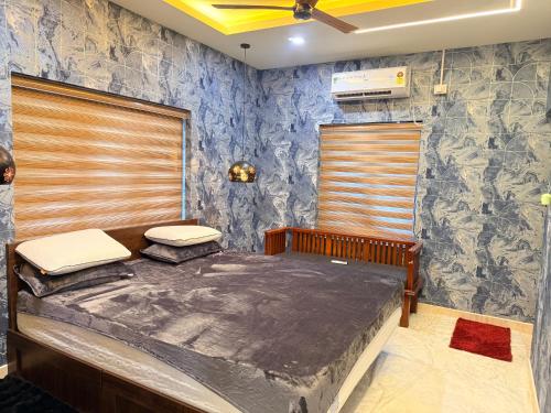 a bedroom with a bed and a blue wall at Winter Heaven in Cochin