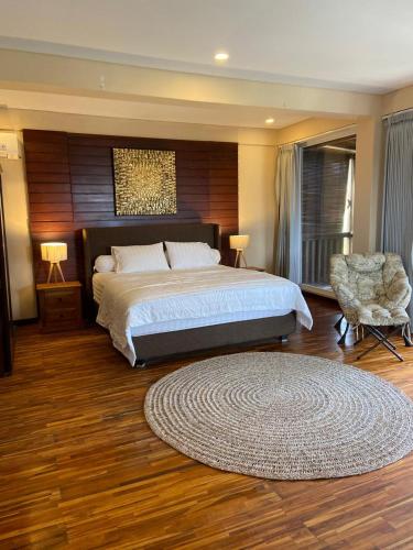 a bedroom with a bed and a chair and a rug at De'Rein Beach House in Sanur