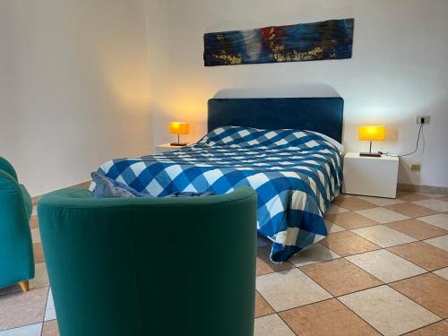 a bedroom with a bed and a green couch at Residence Shopping Outlet in Novi Ligure
