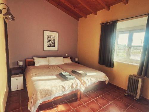 a bedroom with a bed and a window at Casa Presente Guesthouse in Carrapateira