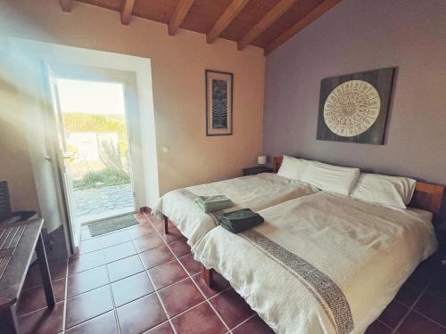 a bedroom with a large bed in a room at Casa Presente Guesthouse in Carrapateira