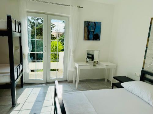 a bedroom with a bed and a desk and a window at Villa Sila in Novalja