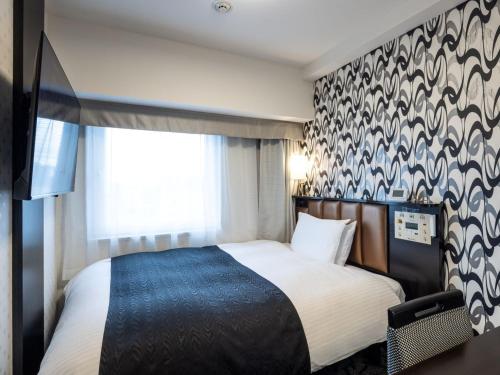 a hotel room with a bed and a window at APA Hotel & Resort Niigata Ekimae Odori in Niigata