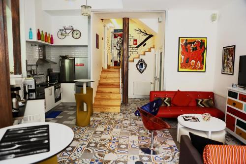 a living room with a red couch and a kitchen at House Petit Lusa in Lisbon