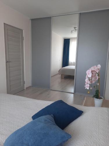 a bedroom with a large mirror in front of a bed at PA Apartment in Rēzekne