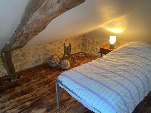 a bedroom with a bed and a table with a lamp at Le Moulin du Clapier - La Ficelle in Sorges