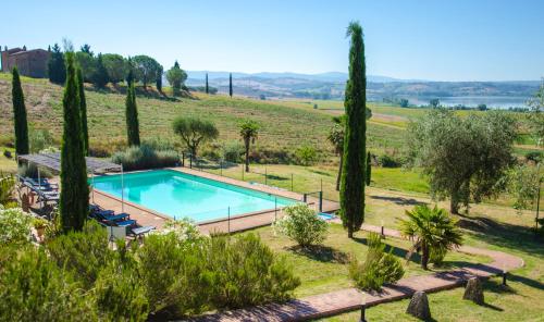 a swimming pool in a garden with trees and a field at Agriturismo Poggio Antico in Binami