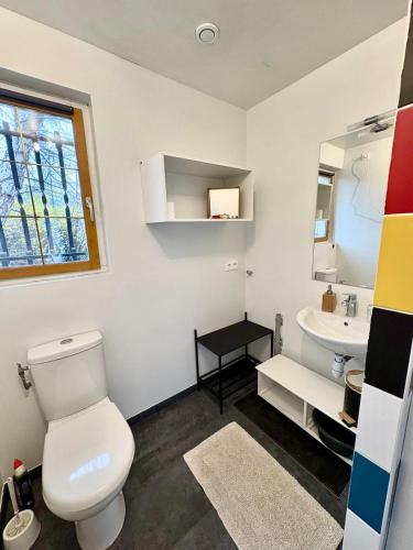 a bathroom with a white toilet and a sink at Le refuge coloré in Gap