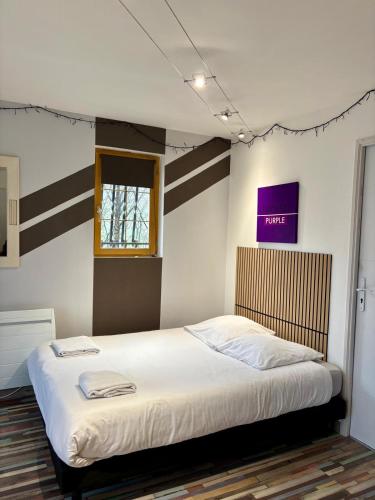 a bedroom with a large bed with white sheets at Le refuge coloré in Gap