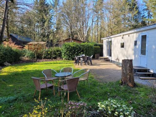 a group of tables and chairs in a yard at Gezellig chalet voor gezinnen op de Veluwe I Veldkamp F16 in Epe
