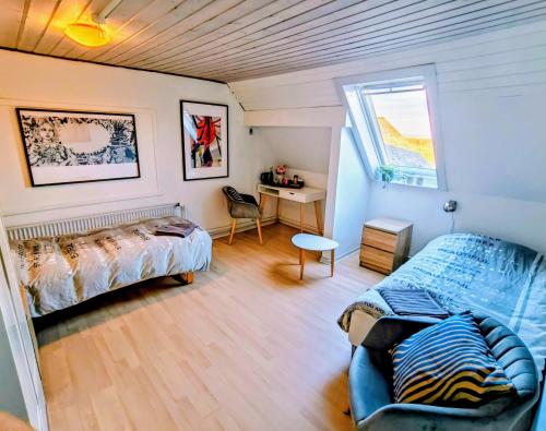 ein Schlafzimmer mit Bett, Schreibtisch und Fenster in der Unterkunft Tåning Bnb in Skanderborg