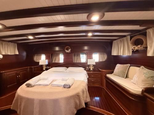 a bedroom in a boat with a bed and a couch at Caicco Silver Star 2 by Blue Marine in Lampedusa