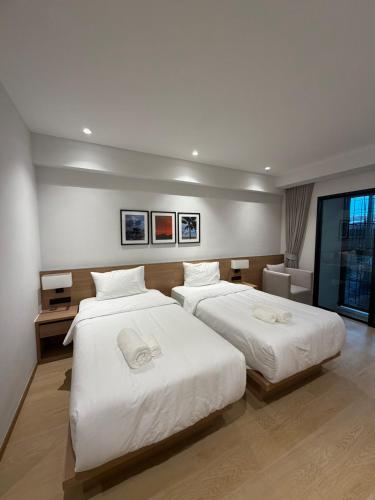 two beds in a hotel room with at 611 Hotel in Phetchaburi