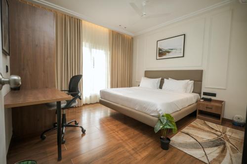 a hotel room with a bed and a desk and a desk at Alpine Resort in Yelagiri