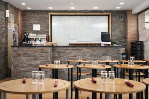 a restaurant with wooden tables and a large screen at Hotel Les Neus in Pas de la Casa