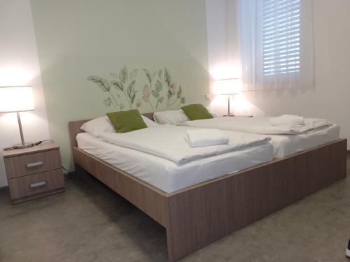 two large beds in a room with two lamps at AIS Center in Wolfsberg
