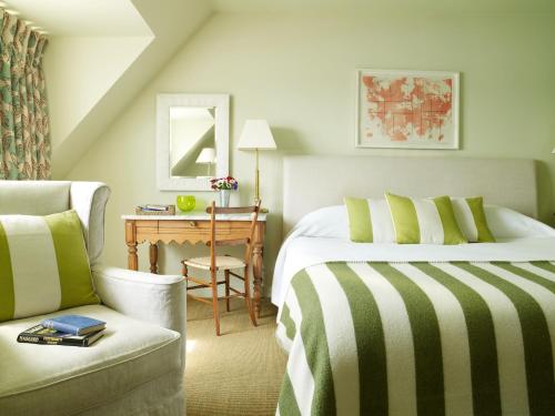 a bedroom with a bed and a chair and a desk at Hotel Tresanton in Saint Mawes