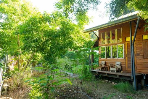 a cabin in the woods with chairs on the porch at MaPin in Ban Thung Kong Mu