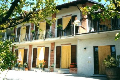 a woman standing on the balcony of a building at Agriturismo Le Viole in Barolo