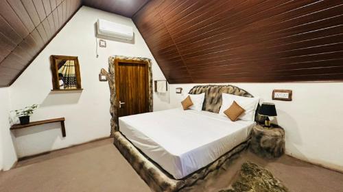 a bedroom with a bed with a wooden ceiling at Nature Nest Cabana in Sigiriya