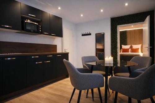a kitchen with a table and chairs and a bedroom at VonMos Moselblick Apartments in Kinheim