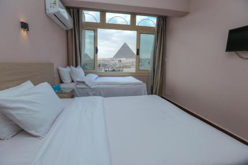 a hotel room with a view of the pyramids at Guardian Guest House in Cairo