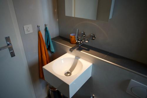 a bathroom with a white sink and a mirror at Chalet Enzian Wirzweli in Dallenwil