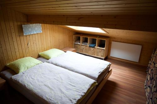 a bedroom with a bed in a wooden room at Chalet Enzian Wirzweli in Dallenwil