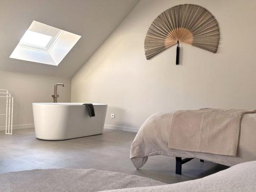 ein Badezimmer mit Badewanne und Fenster in der Unterkunft Moderne woning met 3 kamers voor 7 personen met gratis parking in Haaltert
