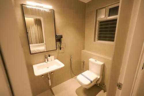a bathroom with a toilet and a sink and a mirror at Alpine Resort in Yelagiri
