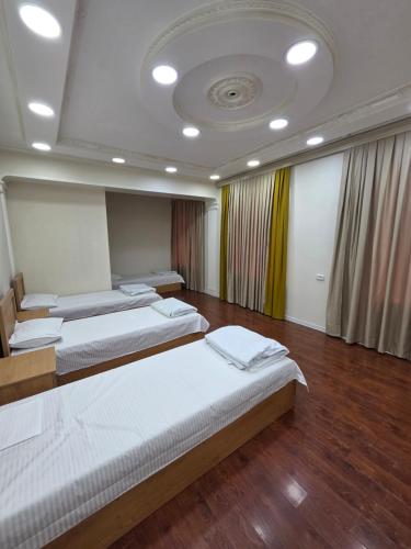a room with four beds in it with a ceiling at Miran Hostel 2 Vokzal in Andizhan