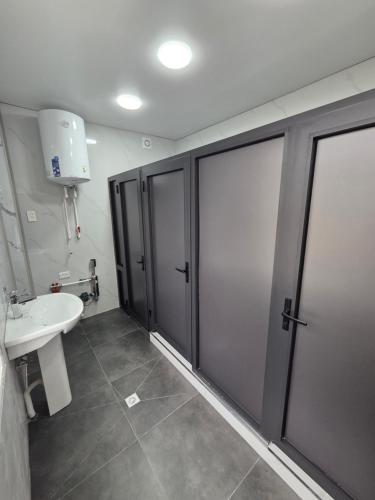 a bathroom with a white sink and a shower stall at Miran Hostel 2 Vokzal in Andizhan