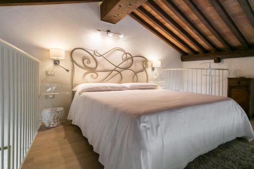 sypialnia z dużym białym łóżkiem w pokoju w obiekcie Relais Pacinotti Apartments w Pizie