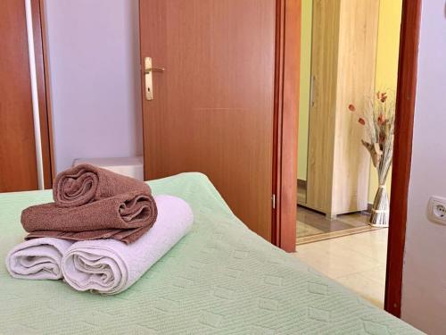 a pile of towels sitting on top of a bed at Apartments Beach in Šilo