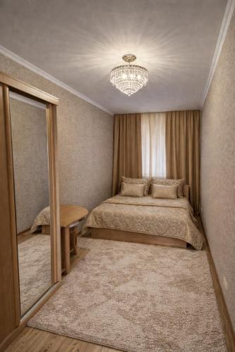 a bedroom with a large bed and a mirror at Аpartments on the main street in Bălţi