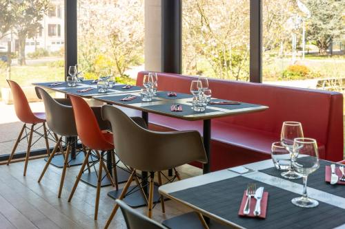 eine Reihe von Tischen in einem Restaurant mit Weingläsern in der Unterkunft ibis Epinal Centre in Épinal