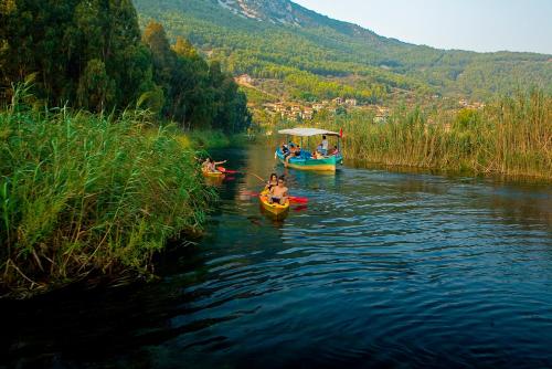 a group of people in boats on a river at Yucelen Hotel in Akyaka