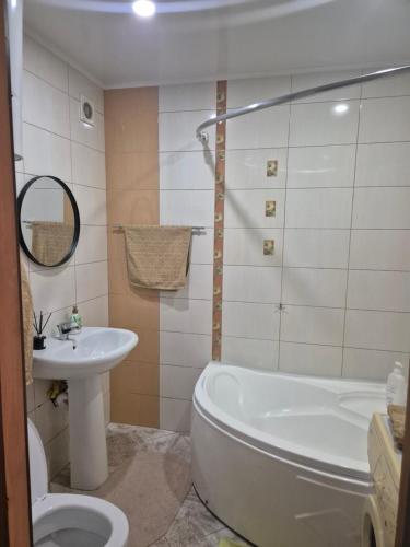 a bathroom with a tub and a toilet and a sink at Аpartments on the main street in Bălţi