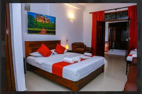 a bedroom with a large bed with red pillows at Elsy Villa Negombo in Negombo