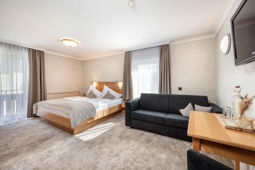 a hotel room with a bed and a couch at Hotel Stegerbräu in Radstadt