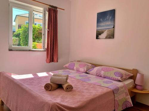 a bedroom with a bed with a stuffed animal on it at Apartments Beach in Šilo
