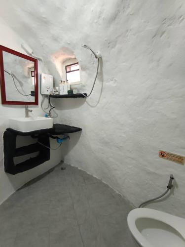 a white bathroom with a sink and a mirror at Art rock garden in Ko Lipe