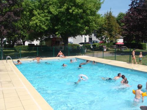 a group of people swimming in a swimming pool at CAMPING LE SAILLET Lestelle Betharram in Lestelle-Bétharram